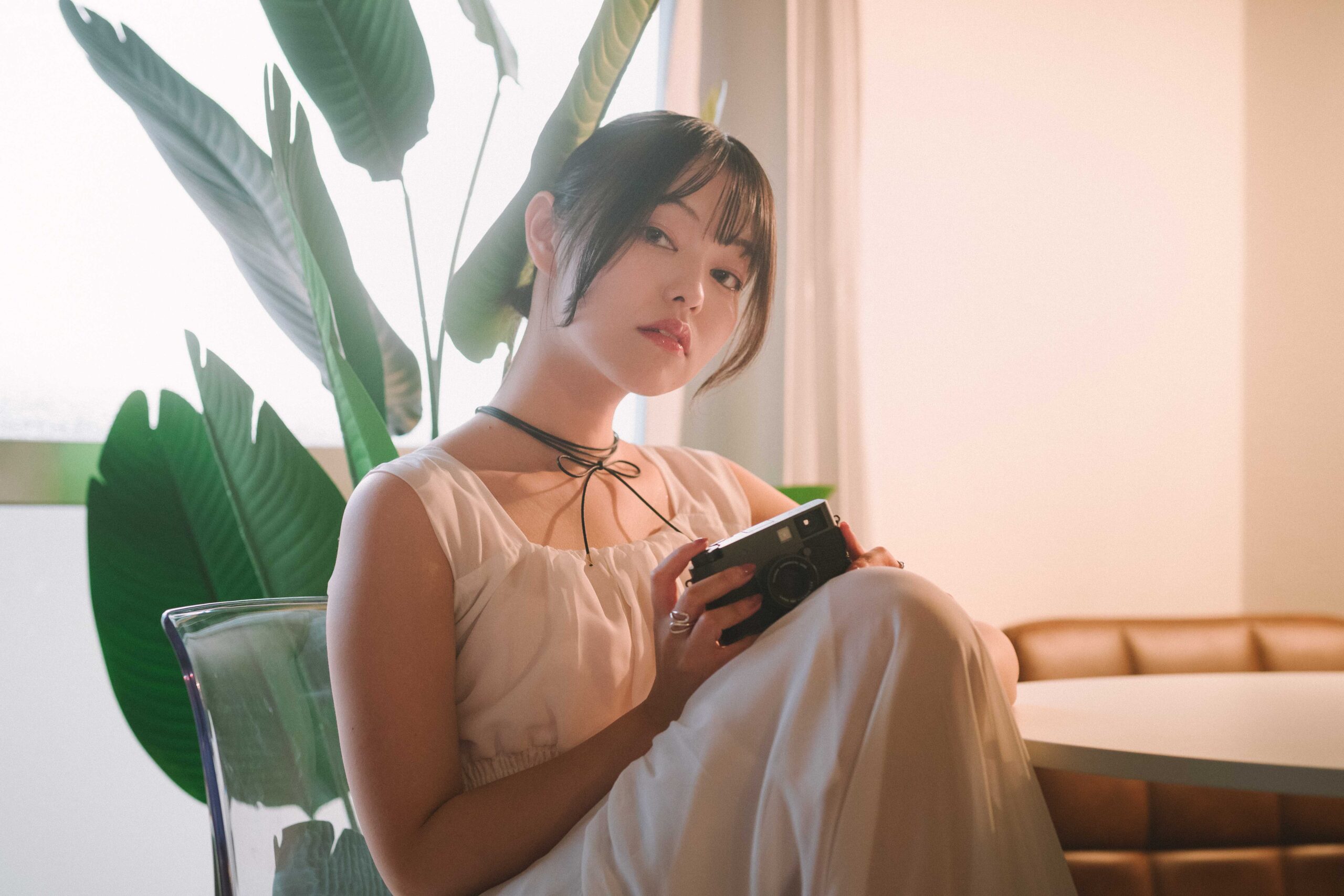 室内でフィルムカメラを手にするポートレート - Photoshopで仕上げた作例